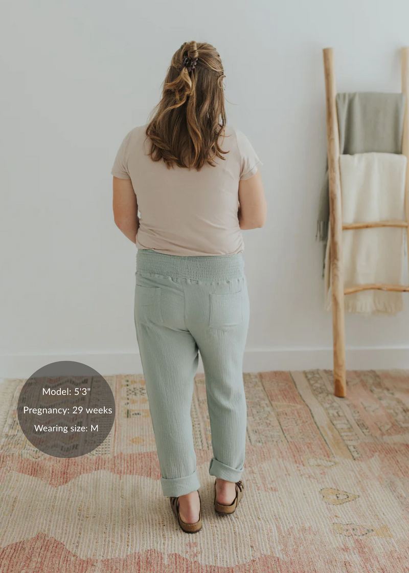 Woman from behind wearing light green cotton gauze Everyday Breeze Pants with an elastic waistband and back pockets.