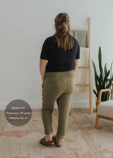 Woman from behind wearing olive green cotton gauze Everyday Breeze Pants with an elastic waistband and pockets.