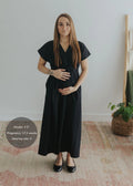 Woman in black cotton poplin waist-gathered dress, size S, 17.5 weeks pregnant.