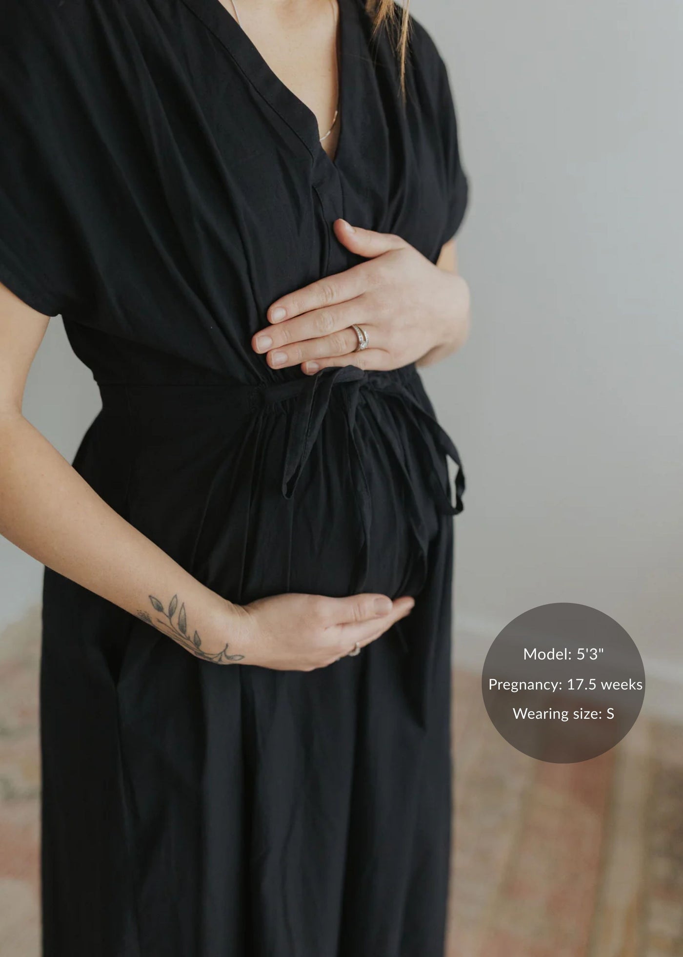 Black cotton poplin waist-gathered dress on a pregnant model, highlighting the tie-waist detail.