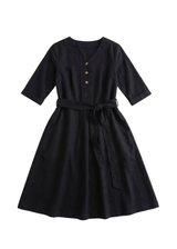 Black cotton-linen Willow Dress with V-neck, button-down front, adjustable waist tie, and flared knee-length skirt.