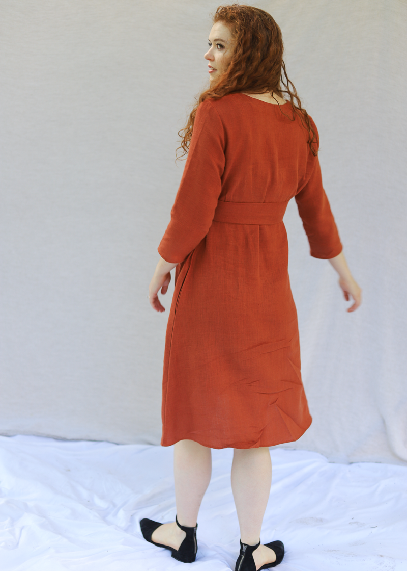 The Faye Dress in softened linen, showing the tie waist and side pockets.