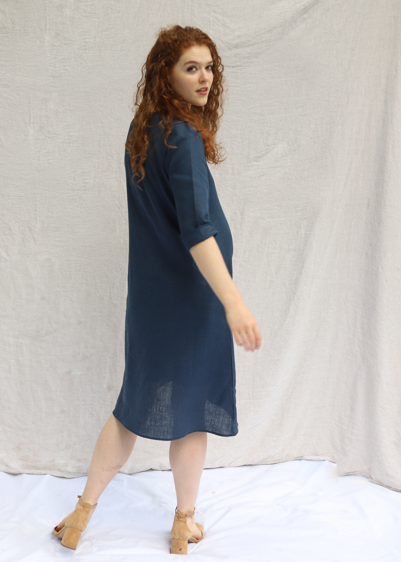 Woman wearing the Faye Dress in softened linen with a V-neck and front buttons.