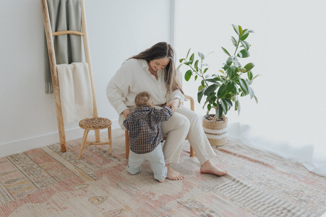 Anna Joy playing with her son in a sunlit studio